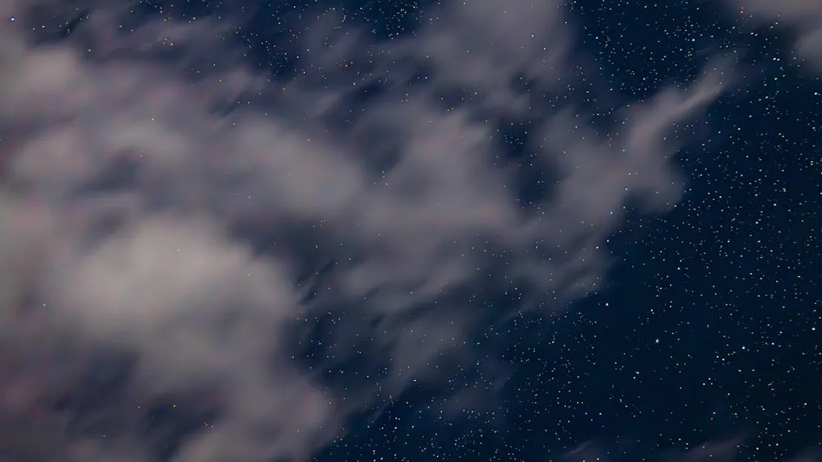A serene night sky filled with stars and scattered clouds, perfect for astronomy lovers.