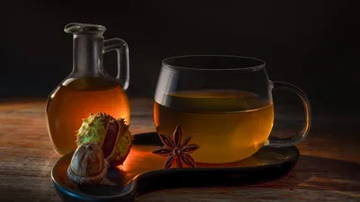 Cozy autumn scene with herbal tea, star anise, and chestnuts on a wooden surface, conveying warmth and wellness.