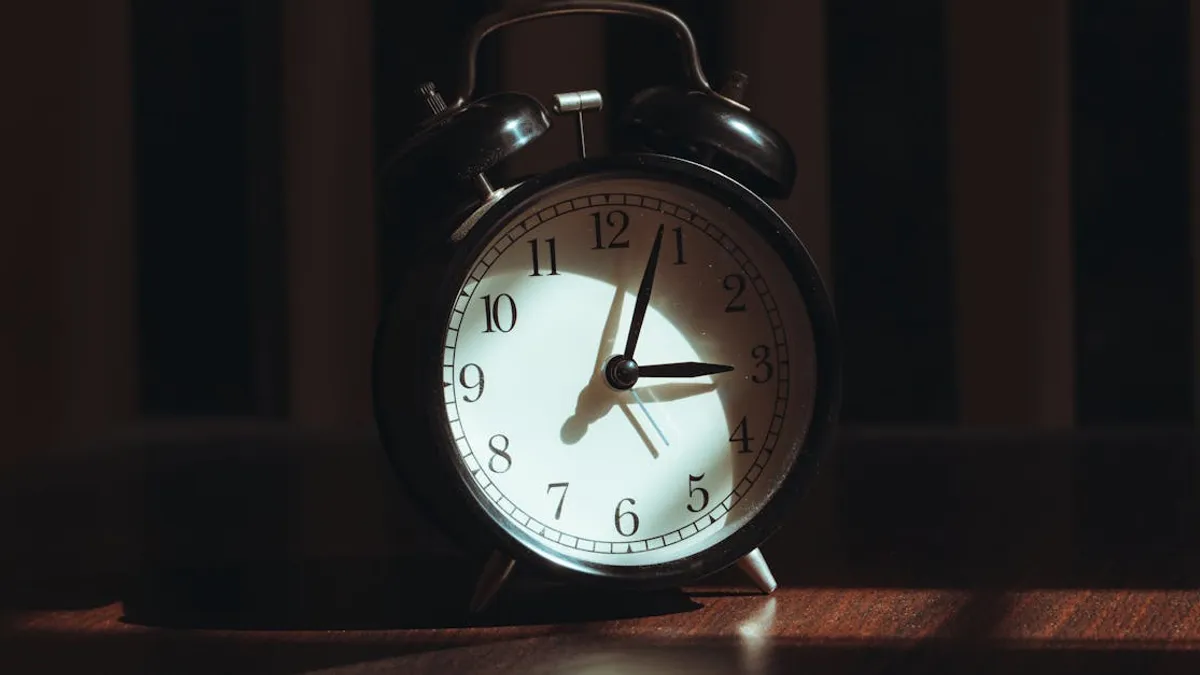A classic black analog alarm clock illuminated by warm light and artistic shadows.